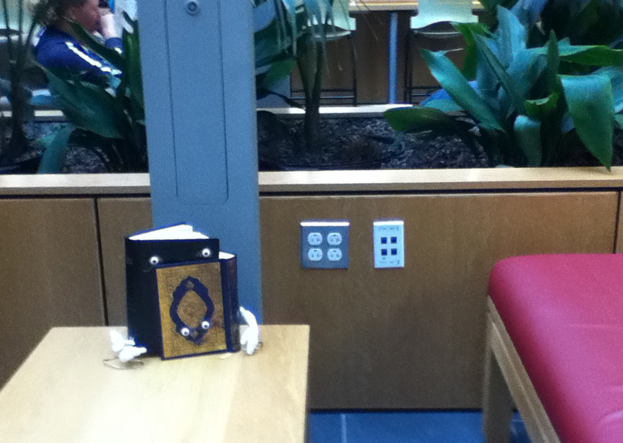 a photograph of the Bible and the Quran hugging on a table at the Portland Public Library Portland, Maine