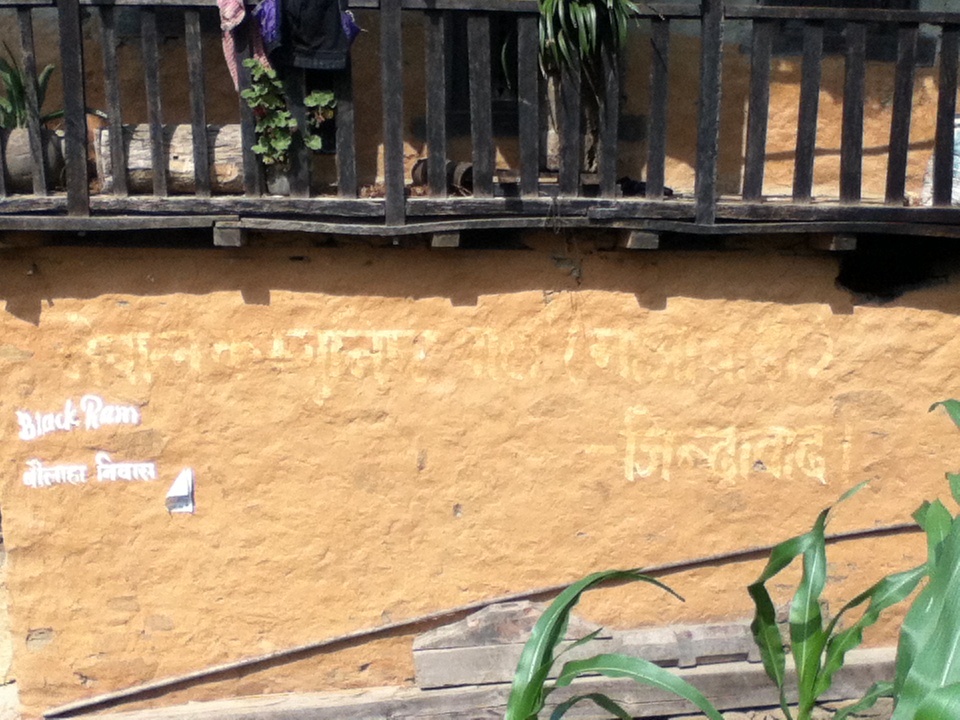 photograph of the wall of a house with writing on it