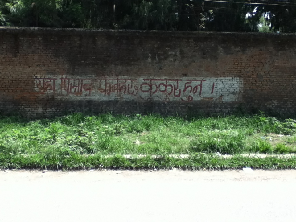 writing on a wall that says, in Nepali, 'Those who urinate here are dogs.'